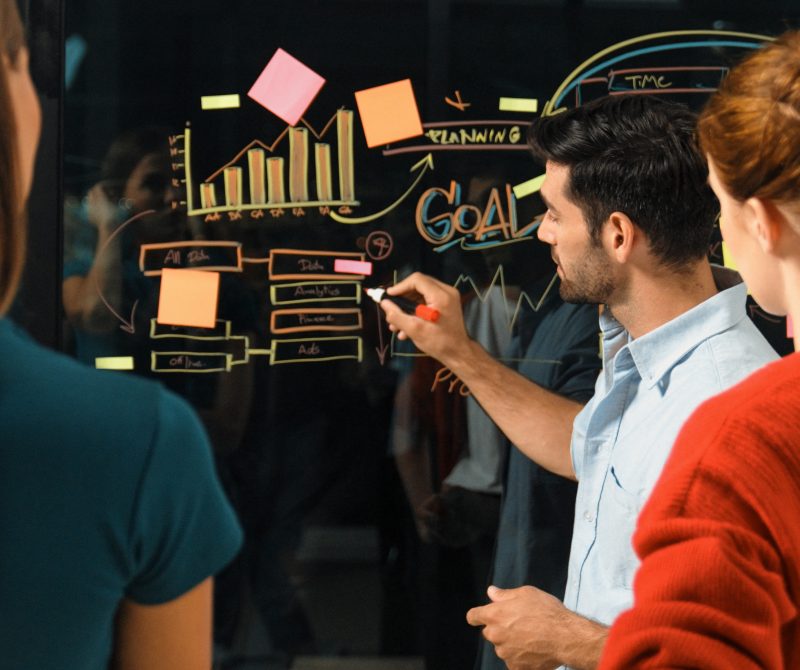 Professional businessman presenting marketing idea or financial plan to smart investor. Executive manager sharing, talking, working together with cooperative colleagues. Business concept. Tracery
