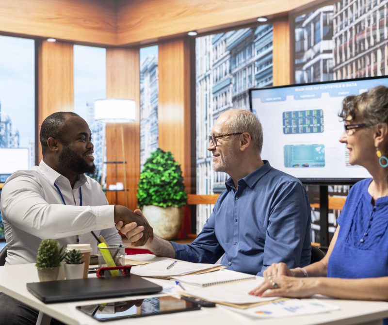 Financial adviser shaking hands in agreement with elderly man