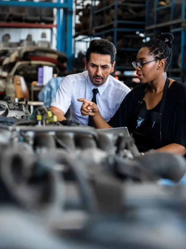 Old auto parts seller check on laptop and explain to customer or boss in store, automobile engine of vehicle, car service fix, inspector and mechanical worker concept