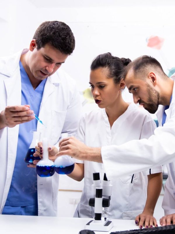 team-scientist-white-coat-working-together-with-smoking-blue-liquid-modern-research-lab