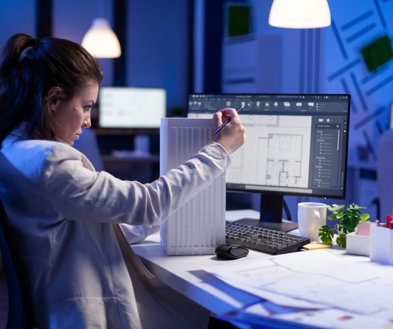 Woman architect analysing and matching blueprints for new building project
