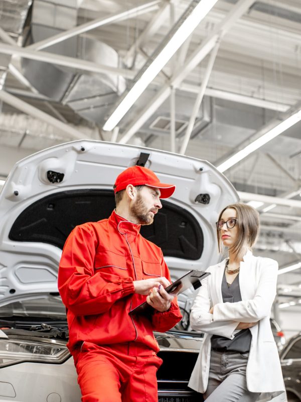 Woman client with auto mechanic at the car service