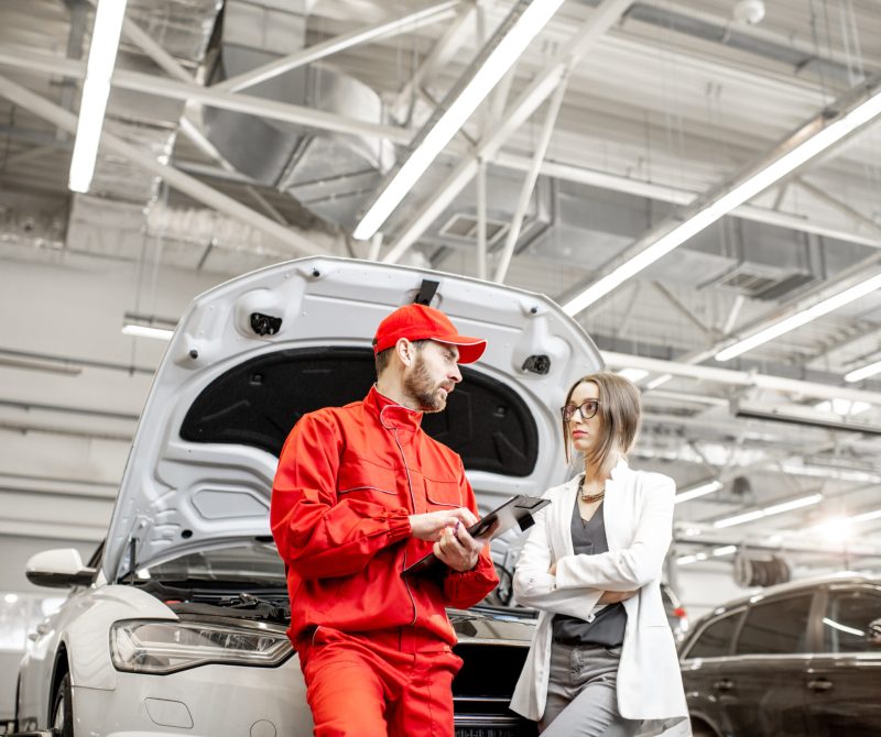 Woman client with auto mechanic at the car service