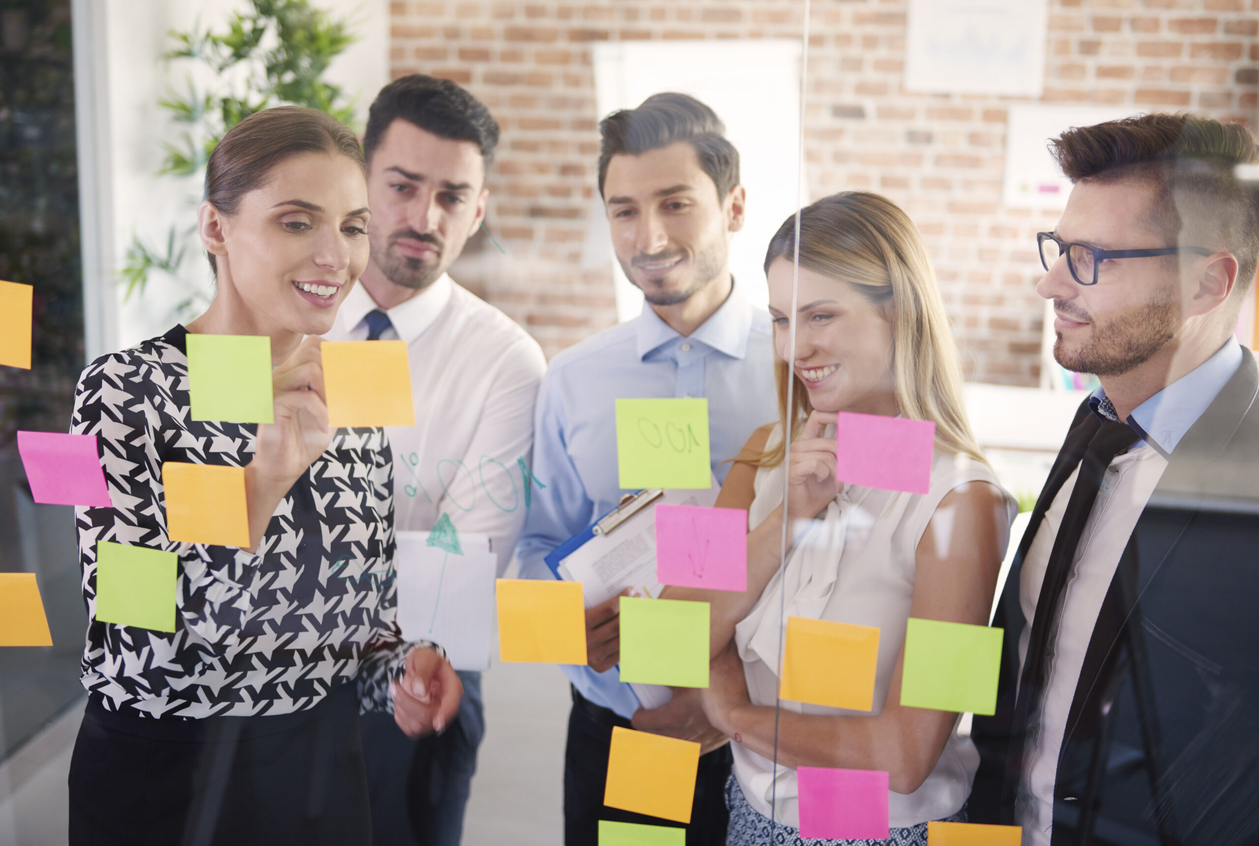 Team behind glass with colorful papers