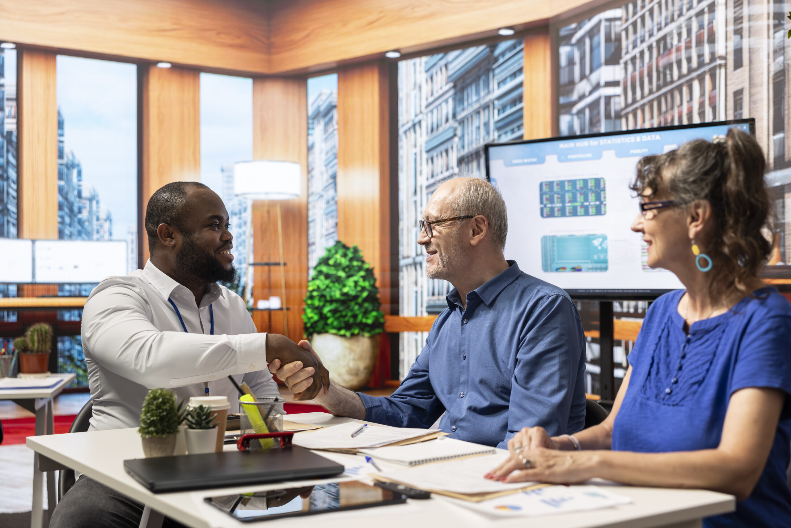 Financial adviser shaking hands in agreement with elderly man Financial adviser shaking hands in agreement with elderly man