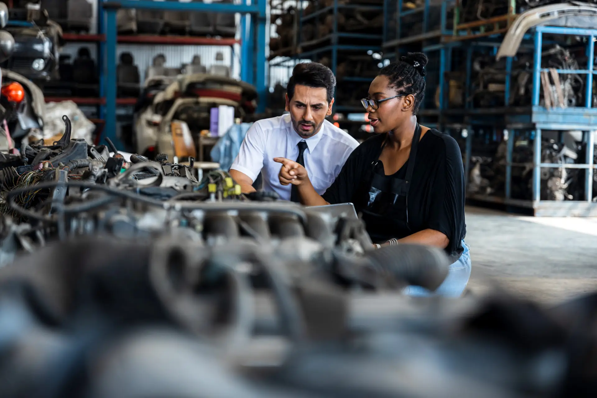 Old auto parts seller check on laptop and explain to customer or boss in store, automobile engine of vehicle, car service fix, inspector and mechanical worker concept